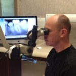 Dr. Jason S. Allen examining teeth with equipment