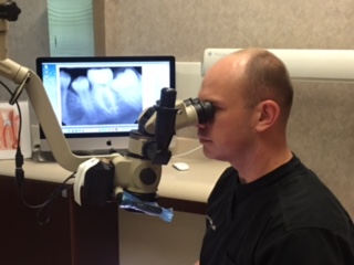 Dr. Jason S. Allen examining teeth with equipment